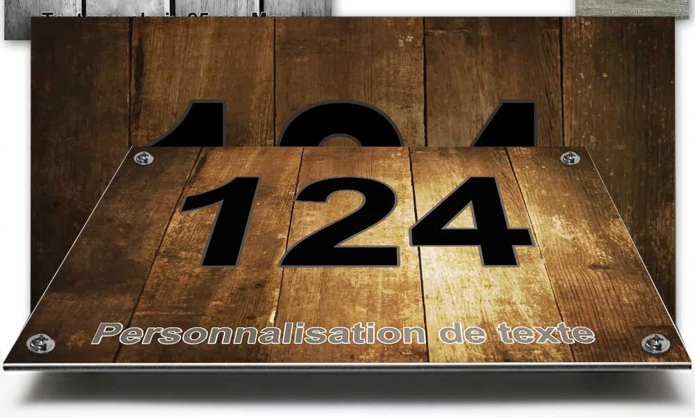 Plaque numéro de maison effet chêne miel posée sur un mur de pierre