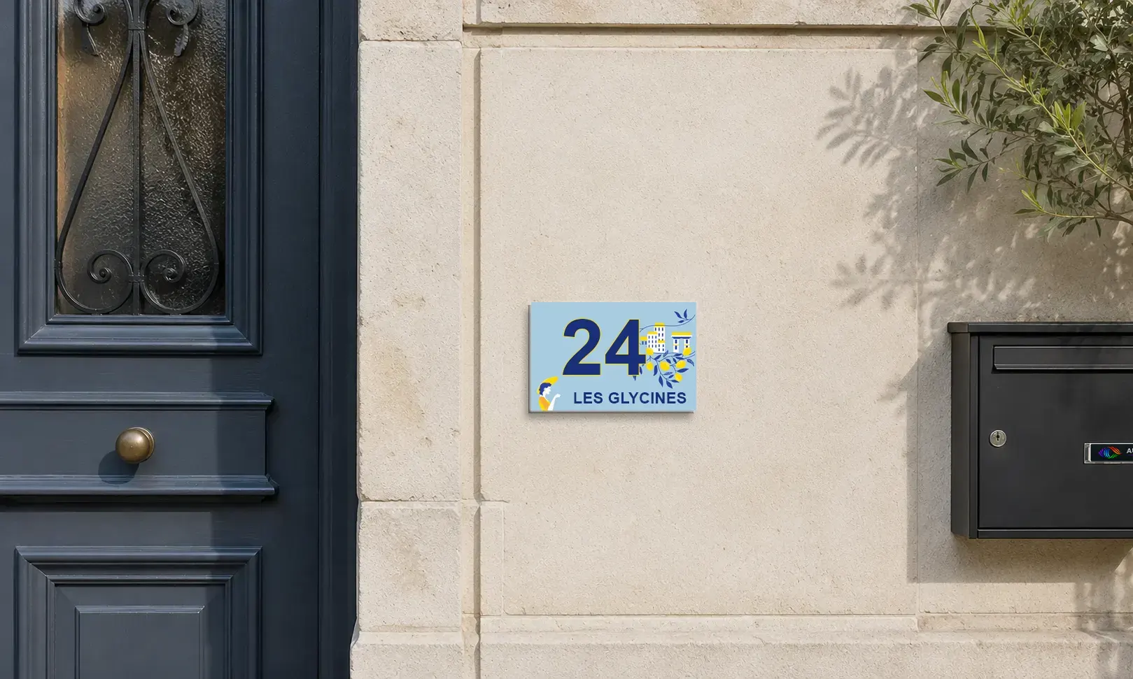 Façade de maison de ville en pierre claire, entre la porte d’entrée et la boîte aux lettres